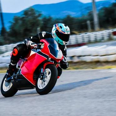 Man riding red and black sports bike in race track