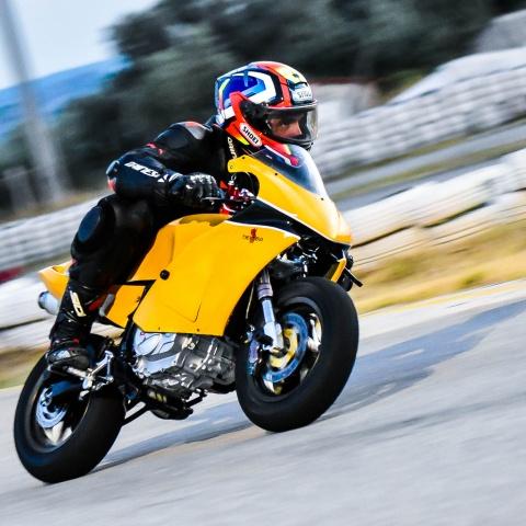 Biker riding yellow sports bike in race track