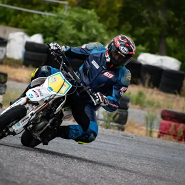 biker riding white pitbike in race track