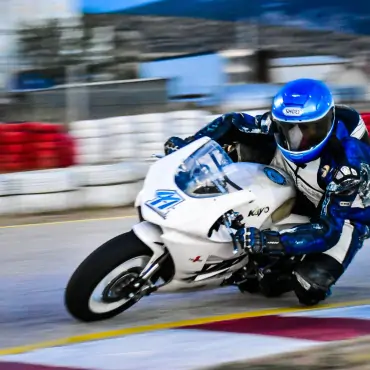 Man riding white sports bike in race track