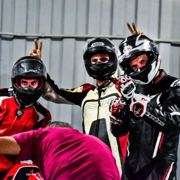three bikers wearing sports helmets and suits posing