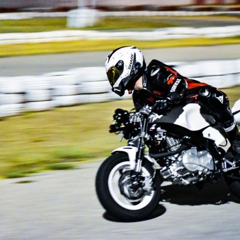Biker riding white pit bike in race track