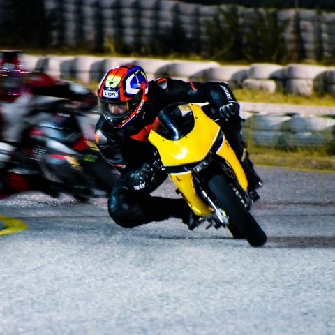 Biker riding yellow and black sports bike in sports race