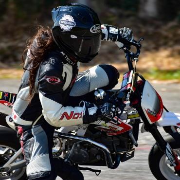 biker riding white and red pitbike in race track