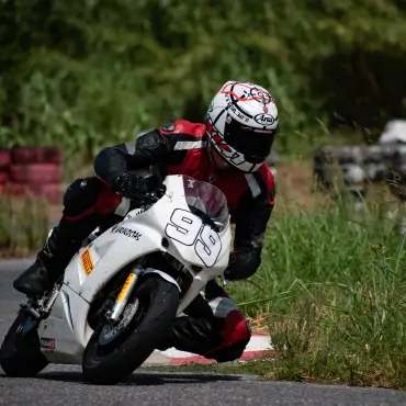 biker riding white sports bike in race track