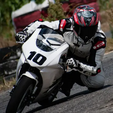 biker riding white sports bike in race track