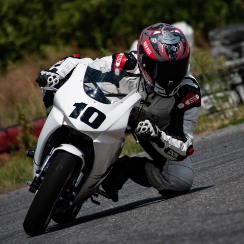 biker riding white sports bike in race track