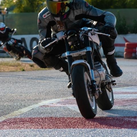 Biker riding white and black pit bike in race track