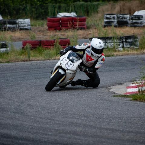 biker riding white sports bike in race track