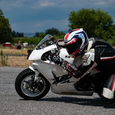 biker riding white sports bike in race track