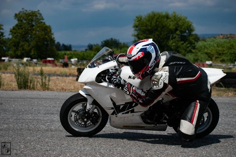 biker riding white sports bike in race track