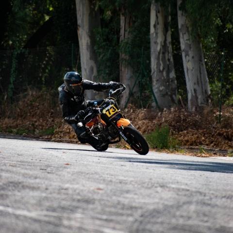 Biker riding orange and red-motorbike in race track