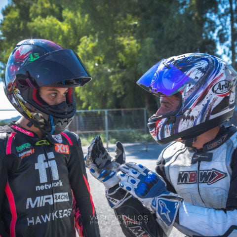 Two riders they talk and they wear their helmets
