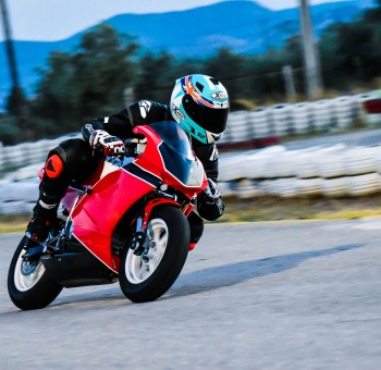 Man riding red and black sports bike in race track